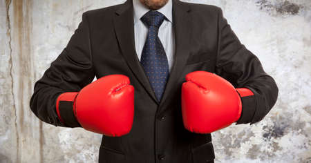 Businessman in red boxing gloves on backgroundの写真素材