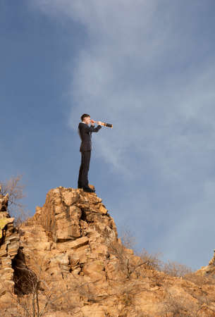 Businessman looks through a telescope. Concept for businessの写真素材