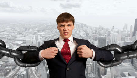 Businessman with several sections of huge chainの写真素材