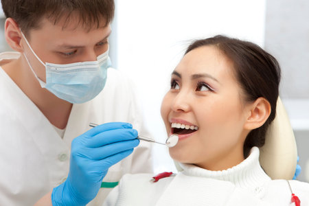 Young woman keeping her mouth open while dentist examining it. Dental photo series