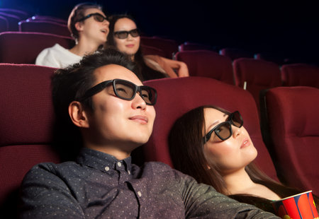 Young couple sitting at the cinema, watching a film. Cinema photo series