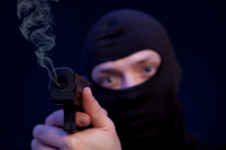 Man holding gun over dark blue backgroundの写真素材