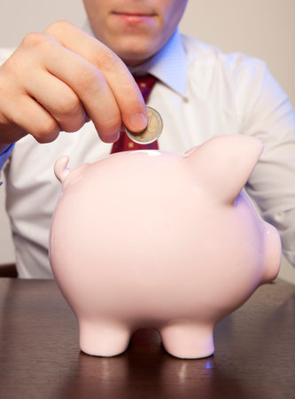 Businessman with pink piggy bank and coinの写真素材