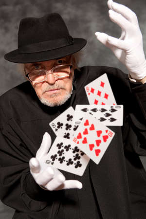Magician show with playing cards. On grey backgroundの写真素材