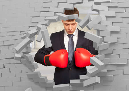 Businessman in red boxing gloves and brick wallの写真素材