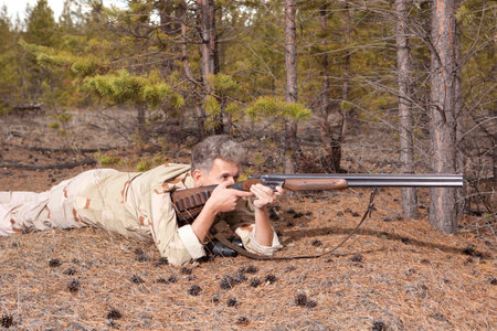 Hunter in camouflage clothes ready to hunt with hunting rifle