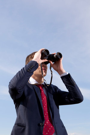 Business concept. Businessman looks through a binocularsの写真素材