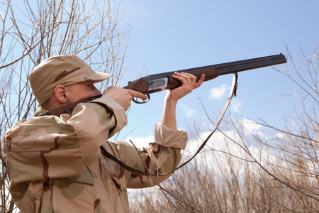 Hunter in camouflage clothes ready to hunt with hunting rifle