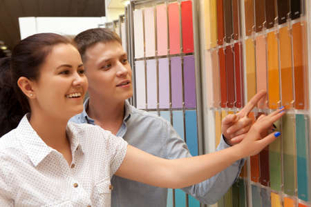 Couple select paint color and look matching samples at household storeの写真素材