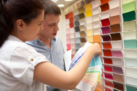 Couple select paint color and look matching samples at household storeの写真素材