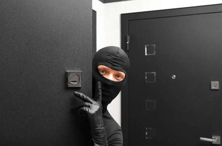 Ninja. Robber hiding behind a door with space for textの写真素材