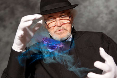 Magician in top hat showing trick. Magic, performance, circus, show conceptの写真素材