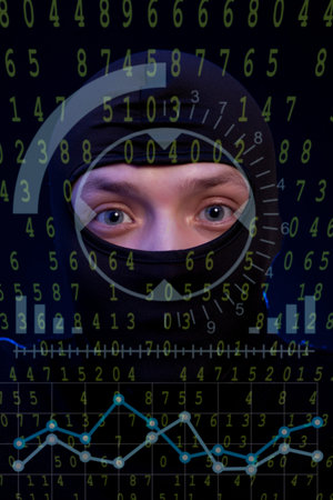 Hacker with black balaclava over a screen with binary code