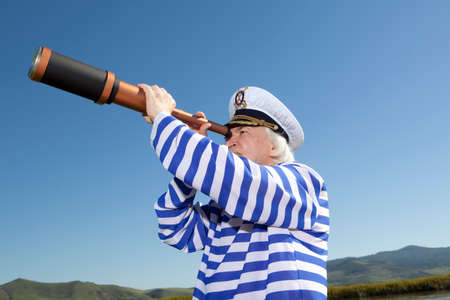 Captain looks through a telescope. Marine conceptの写真素材