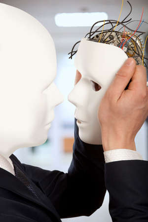 Cyborg, clone, robot and artificial man concept -  Businessmen android robot holds clone white face maskの写真素材