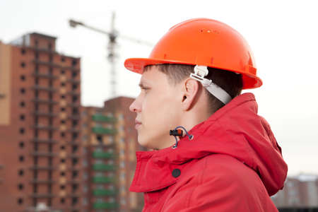 Engineer builder in helmet at construction site, near new buildingの写真素材