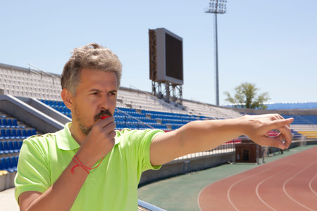 People, sport and soccer concept - man referee whistling pointing