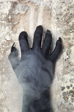 Black hands of the devil on wall background. Horror conceptの写真素材