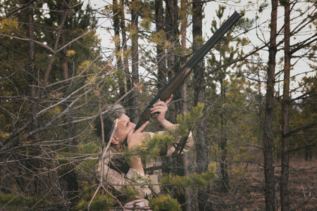 Hunter in camouflage clothes ready to hunt with hunting rifle