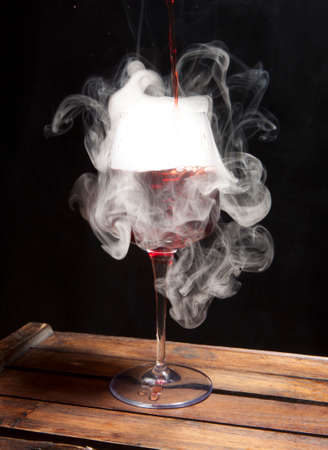 Splash of red wine in the glass on dark backroundの写真素材