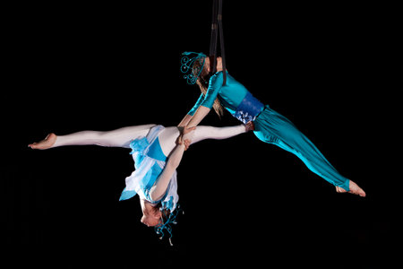 Young couple circus air gymnast. On black backgroundの写真素材