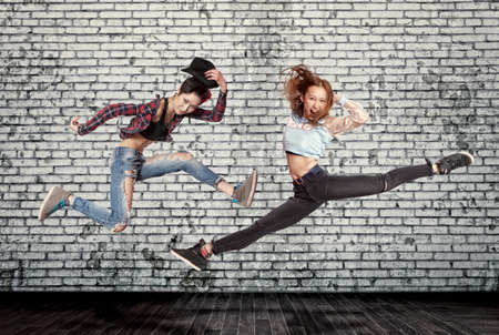 Young woman modern ballet dancing on wall backgroundの写真素材