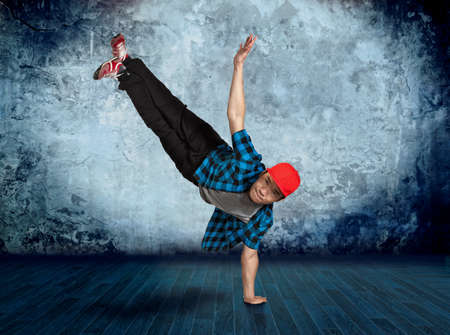 Young man break dancing on wall backgroundの写真素材