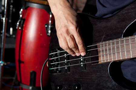 Bass guitar in hands of musician. Musical backgroundの写真素材