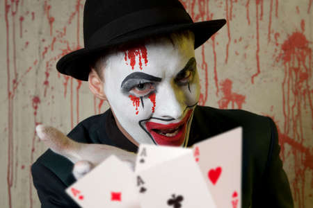 Bluff, Scary evil clown playing with poker cardsの写真素材