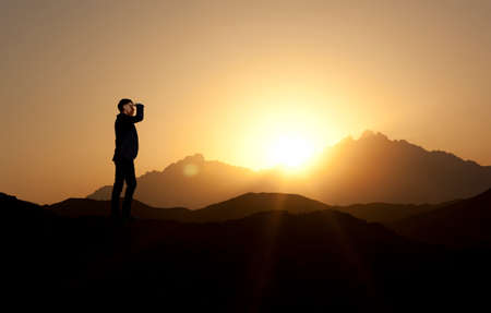 Businessman on the top of the world, above clouds and mountainsの写真素材