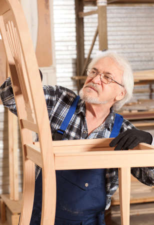 Senior carpenter working in furniture factoryの写真素材