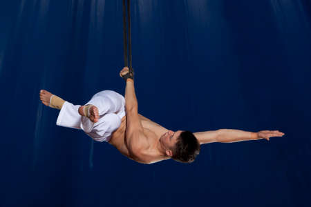 Circus air gymnast on dark blue backgroundの写真素材