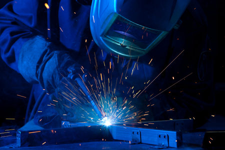 Welder erecting technical steel. Industrial steel welder in factory technical