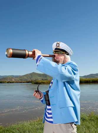 Captain looks through a telescope. Marine conceptの写真素材