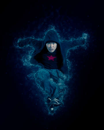Young man break dancing on dark smoke background. Toned imageの写真素材