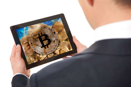 Miner. Businessman working on digital tablet. Gold bitcoin coinの写真素材