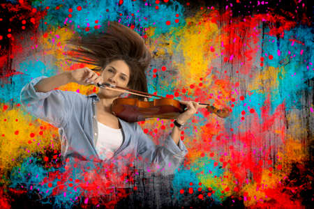 Woman playing violin on on splash backgroundの写真素材