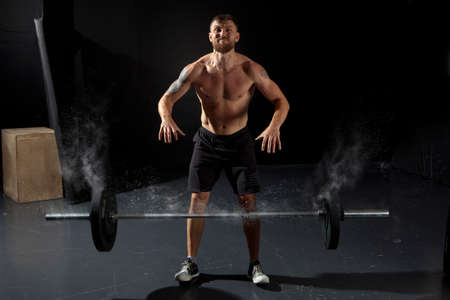 Portrait of a muscular man workout with barbell at gymの写真素材