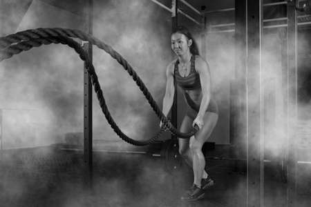 Woman working out with battle ropes at gymの写真素材