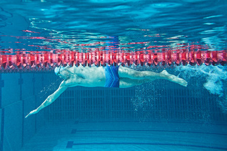 Young man in swimming pool. Underwater