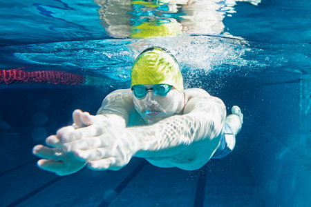 Young man in swimming pool. Underwater