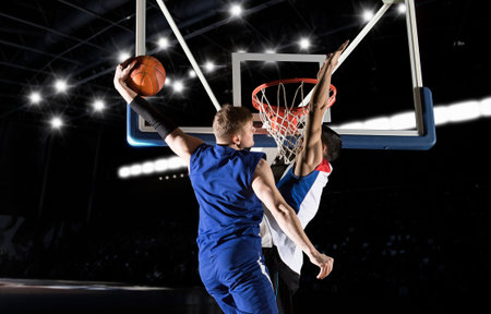 Two basketball players in action in gym