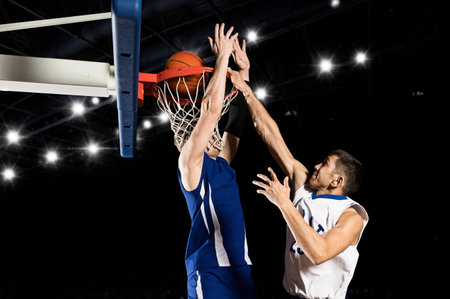 Two basketball players in action in gym