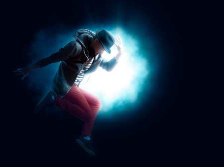 Man break dancing on dark light background