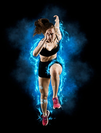 Woman sprinter leaving starting blocks on the athletic track. Exploding start