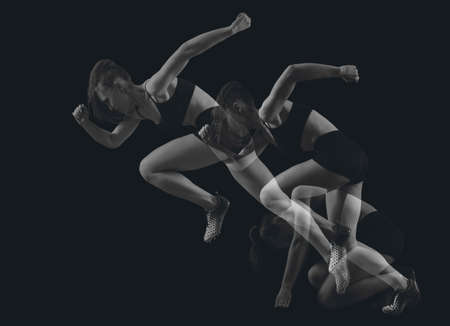 Woman sprinter leaving starting blocks on the athletic track. Double Exposureの写真素材