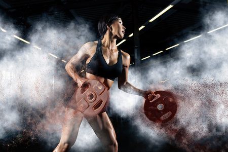 Women workout with disc barbell at gym