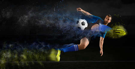 Football player in action on a dark arena backgroundの写真素材