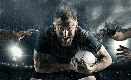 Rugby football player in action on dark arena backgroundの写真素材