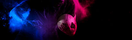 Rugby football player holds ball. Sports banner. Horizontal copy space backgroundの写真素材
